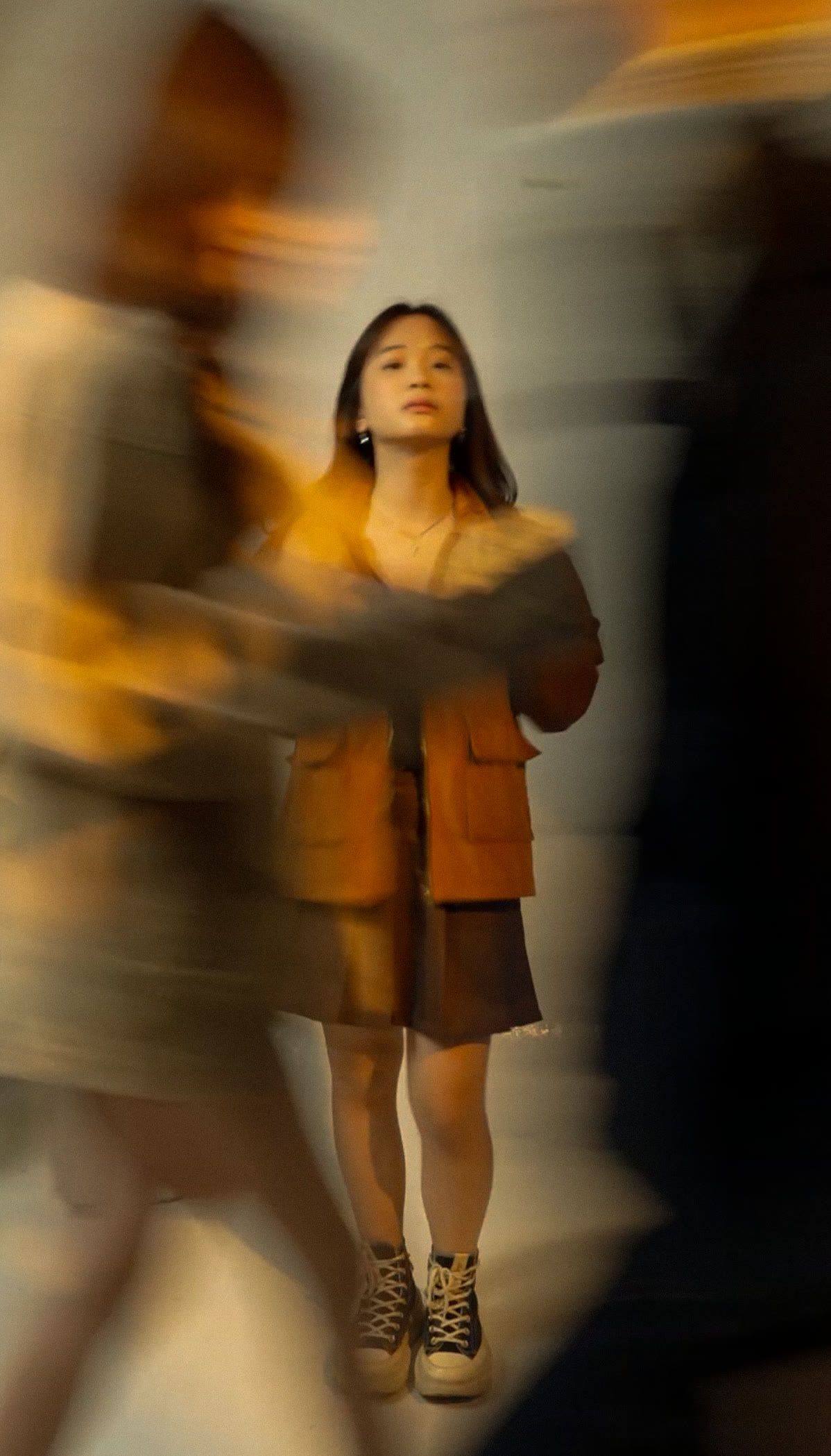 Caramel longneck jacket, a passer-by sweeping through the frame